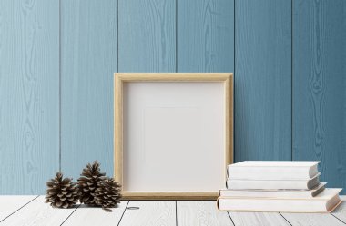 çam kozalakları ahşap zemin üzerinde ve kitaplar ile boş fotoğraf çerçevesi 