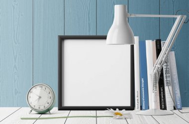 Kitaplar ve çalar saat masa lambası ile yığını ile boş fotoğraf çerçevesi