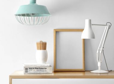 boş fotoğraf çerçevesi ile masa lambası ve yığın tablo kalemleri ile kitap 