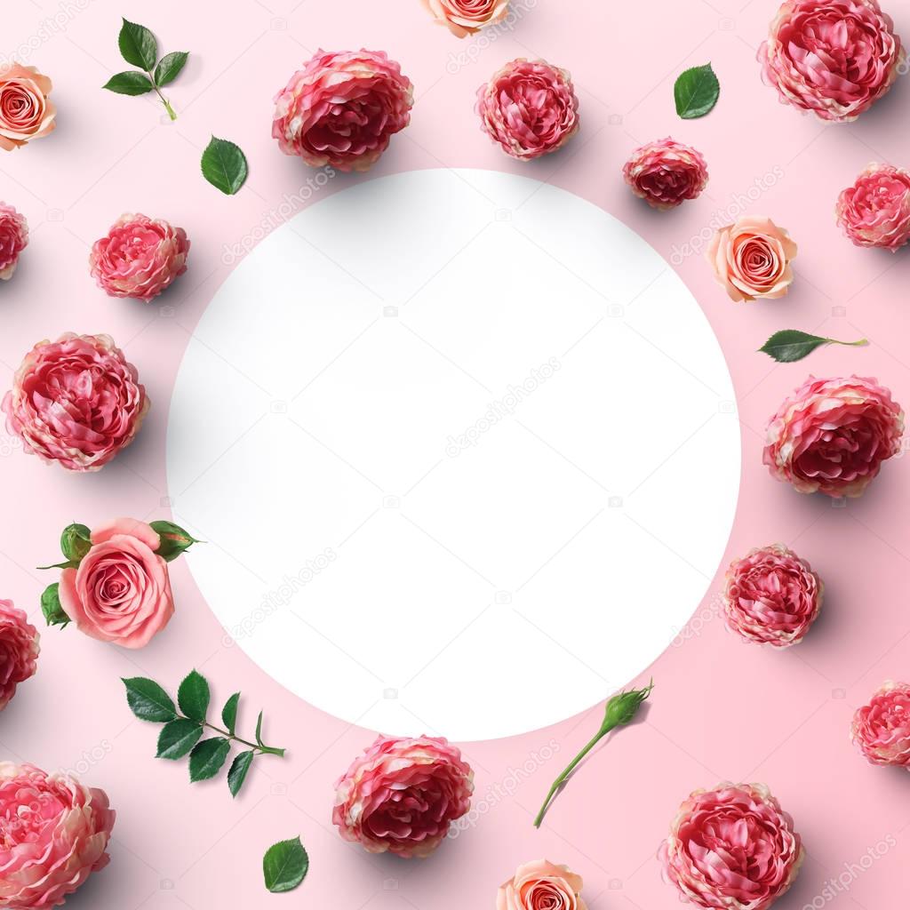 paper card surrounded by rose flowers on pink background