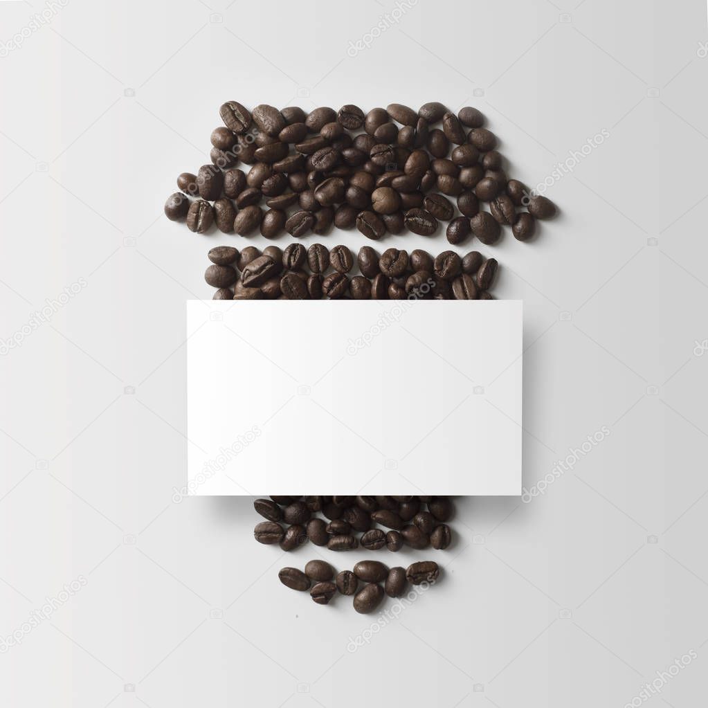 coffee beans with white empty business card in form of paper cup 