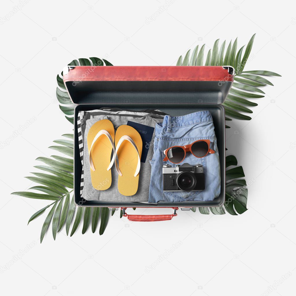 Red open travel bag with clothes on white background