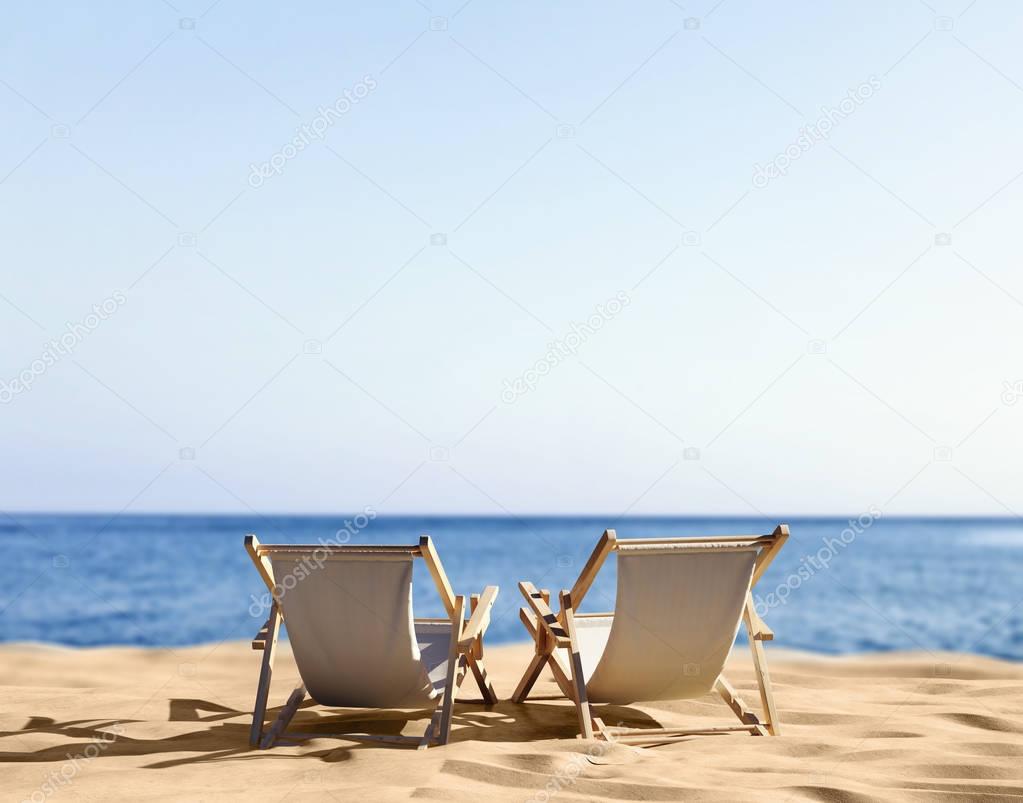 deck chairs on sandy beach of seashore 