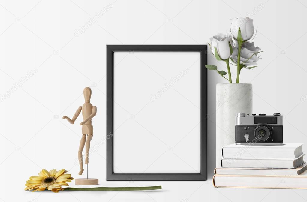 empty photo frame with flowers and camera on books 