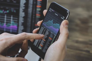 Erkek gösteren grafikler dizüstü bilgisayar arka plan üzerinde smartphone içinde eller