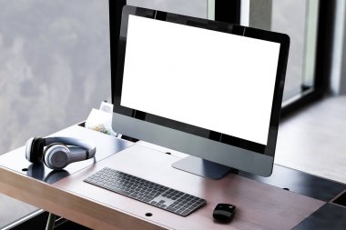 İş yerinde bilgisayar, kulaklık, klavye ve işaretleme aygıtı ahşap masa üzerinde