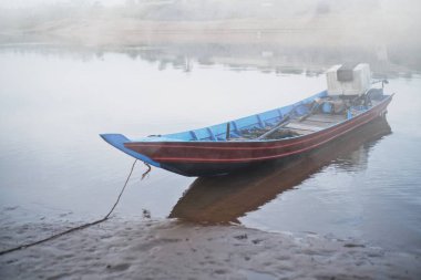 Balıkçının kayığı sabahın erken saatlerinde nehrin kıyısına park edilmiş.