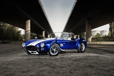 Photoshot of american oldschool roadster in the urban landscape clipart