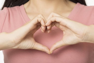 Asyalı kadın ellerini kullanarak bir kalp şekil verme