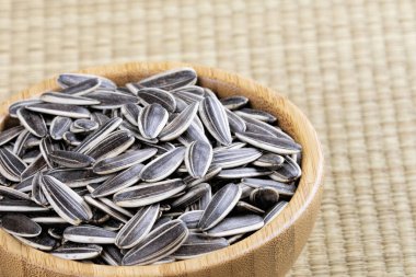 Ayçiçeği tohumlarıyla dolu tahta bir kase.