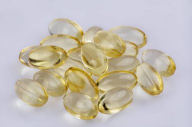 E vitamini Capsulus 'u alan derinliği sığ olan beyaz bir arkaplanda kapat
