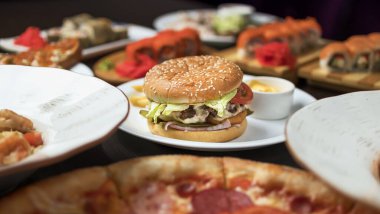 Bir kafede hamburgerler pizza, salata, patates kompozisyonu.