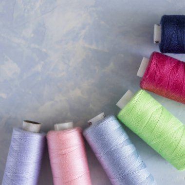 Yumuşak mavi arkaplanda renkli parlak iplikler.