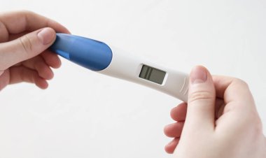 Pozitif elektronik gebelik testi beyaz bir arkaplanı kapatıyor