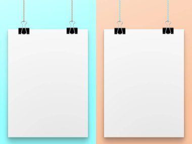 Mavi ve şeftali arkaplanda siyah ataçlara bağlı harfi olmayan beyaz bir tablet.