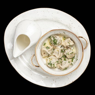 Beyaz tabakta ekşi kremalı sığır eti köftesi. Üst fotoğraf, izole edilmiş, siyah arkaplan.