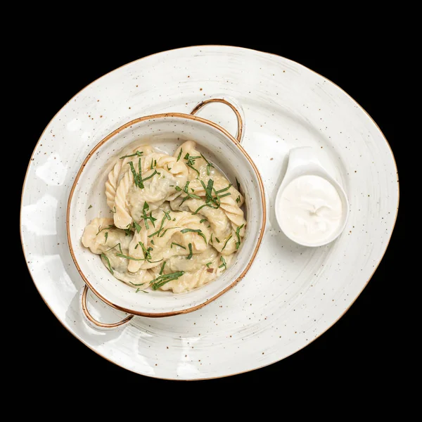 dumplings with mushrooms, cottage cheese with sour cream on a white plate top photo, isolate, black background
