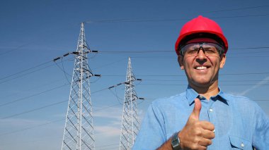 Elektrik İletim Towers yakınındaki gülümseyen işçi