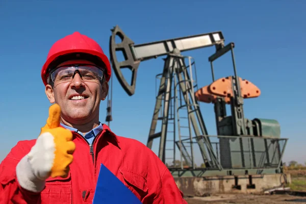 Ölarbeiter gestikuliert mit erhobenem Daumen neben Pumpenheber — Stockfoto