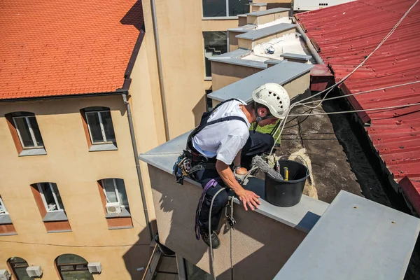 Молодий очищувач вікон спускається з даху будівлі — стокове фото