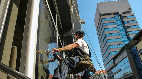 Arbeit mit hohem Risiko - Industriekletterer waschen Fenster — Stockfoto