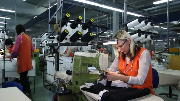 Las trabajadoras trabajan en la línea de costura en la fábrica textil — Vídeos de Stock