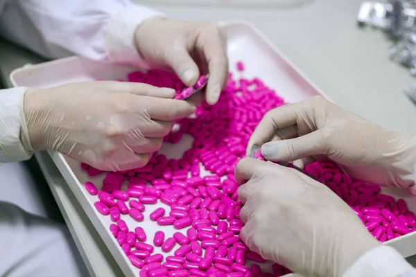 Kvalitetskontroll arbetstagare undersöker piller i Lab — Stockfoto