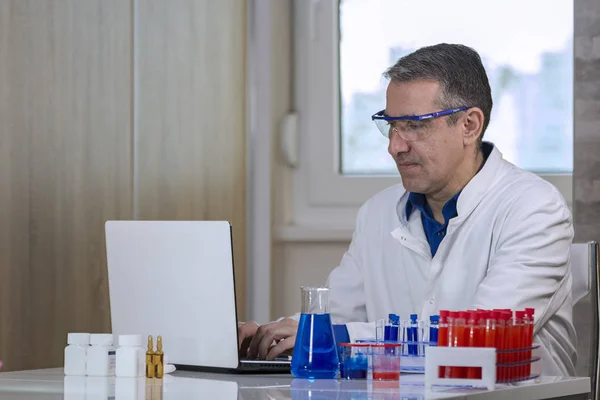 Wissenschaftler tippt im Labor für Biochemie auf Laptop — Stockfoto
