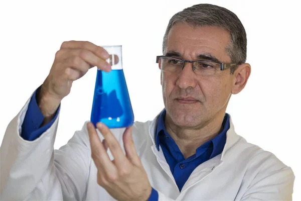 Chemiker hält Becher mit blauer Chemikalie über weißem Hintergrund — Stockfoto