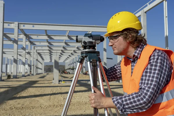 Byggnadsarbetare med takeometer som arbetar på byggarbetsplatsen — Stockfoto