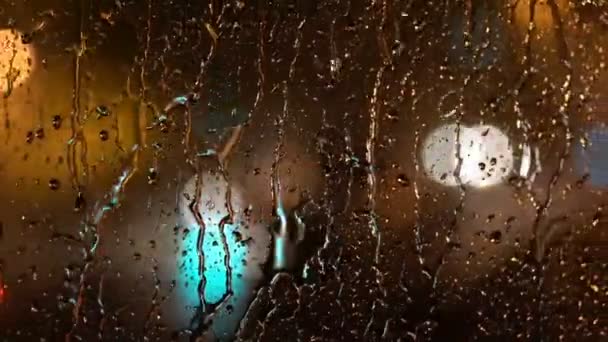 Vista Cidade Desfocada Iluminação Noturna Pela Janela Com Gotas Chuva — Vídeo de Stock