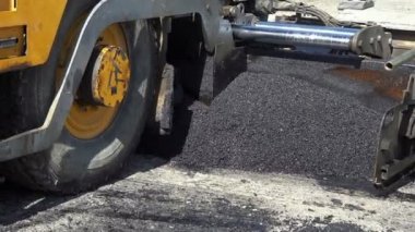 Yol Yapım İşleri - Yeni Asfalt Yolu - Uzaklaş. Bir yol inşaatında asfalt döşeme makinesi. Yol Yapımı sırasında Paving Makinesi Taze Asfalt Yatırıyor.
