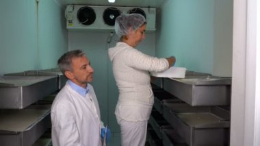 Gıda Fabrikasında Üretim Hattı 'nda İki Çalışan Sohbet Ediyor. Süt bitkisi işçisi kremalı (pıhtılaşmış krema) ayrıştırma üretim hattı. Süt Ürünleri Üretim Tesisi. 