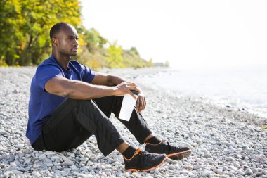 Genç adam sahilde dinleniyor.