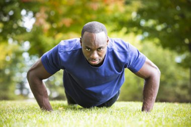 Genç adam dışarıda egzersiz yapıyor.