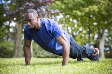 Genç adam dışarıda egzersiz yapıyor.