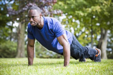 Genç adam dışarıda egzersiz yapıyor.