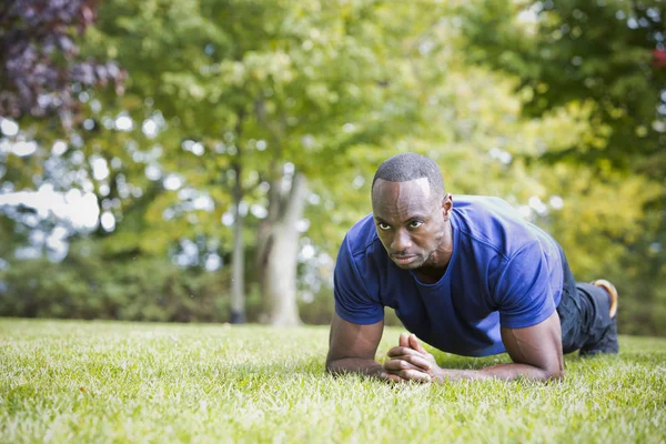 Fit homem fazendo exercício núcleo prancha no parque — Fotografia de Stock