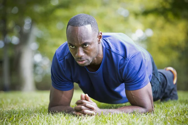 Fit homem fazendo exercício núcleo prancha no parque — Fotografia de Stock