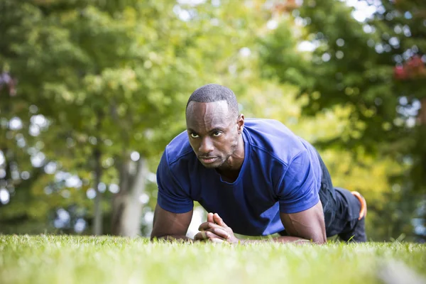 Fit homem fazendo exercício núcleo prancha no parque — Fotografia de Stock