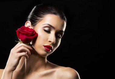 siyah zemin üzerine kırmızı gül tutan romantik kadın