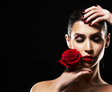 siyah zemin üzerine kırmızı gül tutan romantik kadın