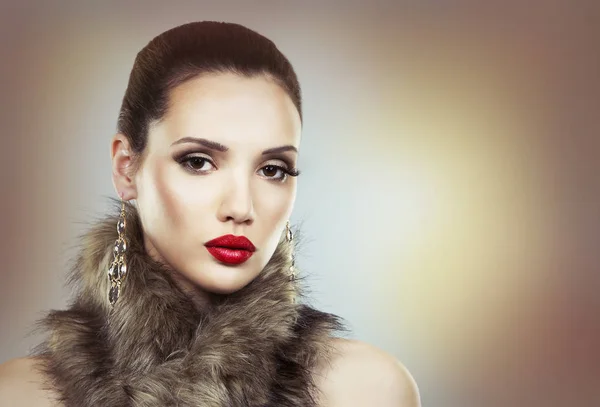 Beautiful brunette with glamour earings and winter fur — Stock Photo, Image