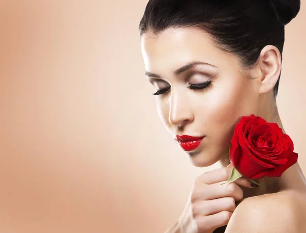 Donna romantica che tiene rosa rossa su sfondo beige — Foto Stock