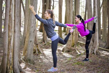 Ormanın ortasında yoga yaparken iki kadın