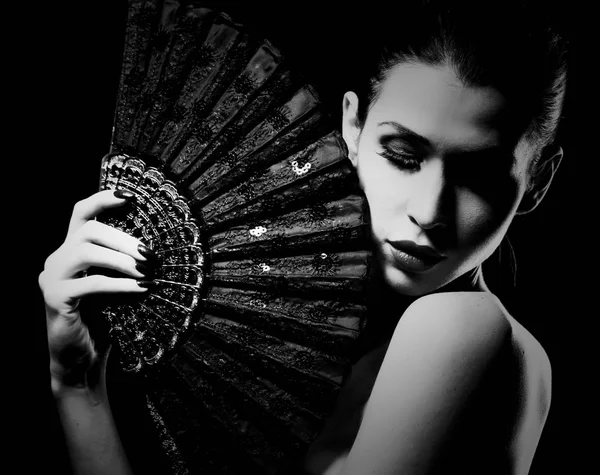 Misteriosa mujer sosteniendo un ventilador en blanco y negro — Foto de Stock