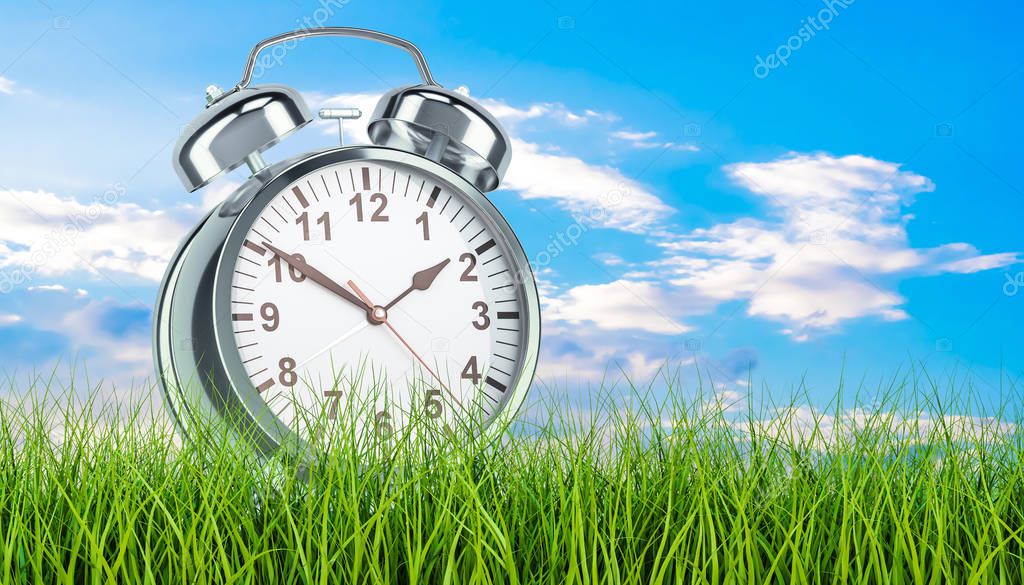 Alarm clock in green grass, 3d rendering