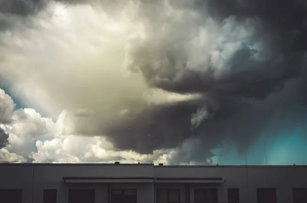 Бурный облачный пейзаж над многоквартирным домом — стоковое фото