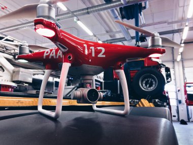 red colored quadcopter in factory room clipart