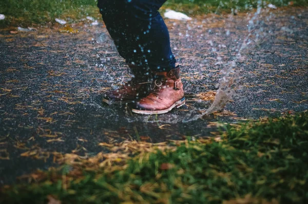 Un chico saltando en el charco — Foto de Stock